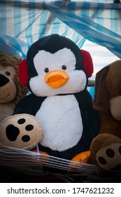 Penguin stuffed animal between other stuffed animals