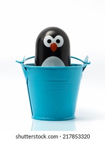 Penguin toy figure in the a bucket