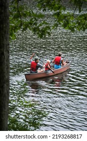 Penn Township, Pennsylvania - August 21 2022: Mother, Father, And Child In A Canoe On A Lake For A Family Vacation