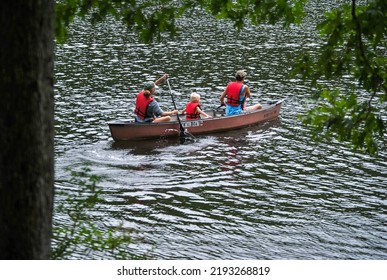 Penn Township, Pennsylvania - August 21 2022: Mother, Father, And Child In A Canoe On A Lake For A Family Vacation