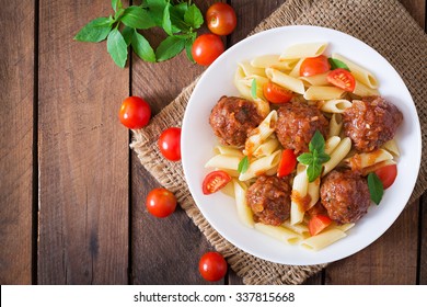 Penne pasta with meatballs in tomato sauce in a white bowl. Top view - Powered by Shutterstock