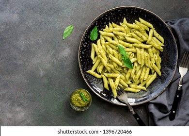 Penne Pasta With Pesto Sauce In A Plate On A Dark Rustic Background. Overhead View, Flat Lay.