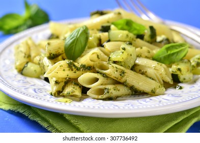 Penne With Zucchini And Basil Pesto On A Blue Background.