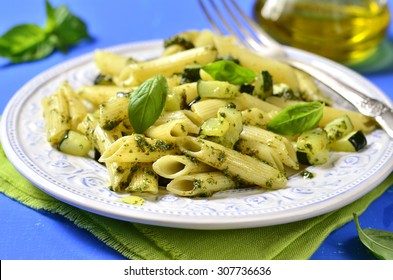 Penne With Zucchini And Basil Pesto On A Blue Background.