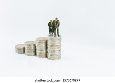 Pension Fund / Plan For Retirement, Financial Concept : Miniature Figurine Seniors, Elder On Steps Of Increasing / Rising Coins On White Background, Depict Preparing Money / Asset For Late Life Cycle