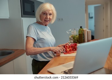 Pensioner Female Cooking In Kitchen At Home