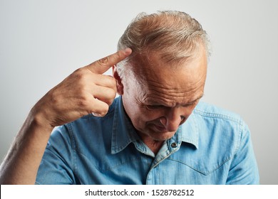 Pensioner Points A Finger At A Gray-haired Balding Head Isolated On A White Background. The Problem Of Hair Loss, Androgenic Alopecia