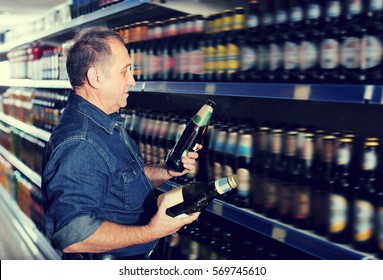 Pensioner Selecting A Beer At The Grocery Store