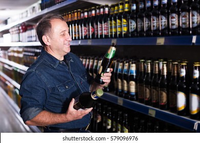 Pensioner Selecting A Beer At The Grocery Store