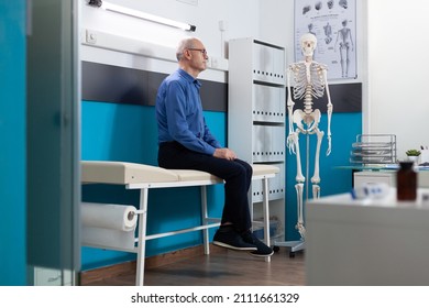 Pensioner Senior Man Standing On Bed Alone In Hospital Office Waiting For Ilness Expertise During Medical Sickness Examination. Medicine Services Support. Recovery Assistance