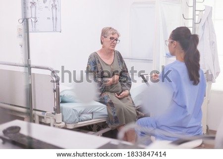 Similar – Female doctor filling out questionnaire to a senior patient