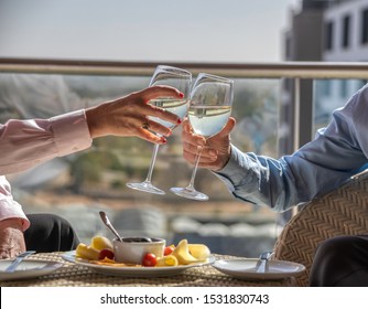 A pensioners couple enjoying a glass of white wine and a snack on the terrace of their flat