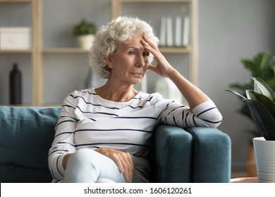 Pensive 70s Woman Sitting On Couch Thinking About Difficulties Of Life Personal Failure Bad Period, Health Problems Feeling Fatigue And Tiredness Resting At Home, In Sad Thoughts And Troubles Concept