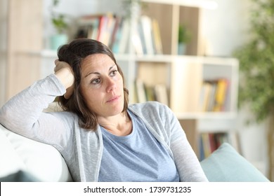 Pensive Adult Woman Thinking Looking Away Sitting On The Couch At Home