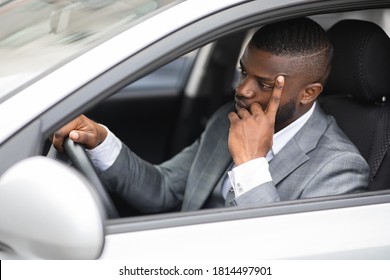 Pensive african american businessman leaning on his hand while driving car. Side view of frustrated young black man in suit holding touching his face, driving from business meeting, having bad day - Shutterstock ID 1814497901