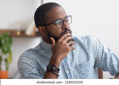 Pensive African American businessman pondering business strategy, serious employee thinking about project, problem solution, looking in distance, puzzled manager making decision, close up