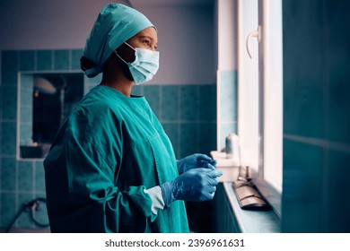 Pensive African American female surgeon before the surgery in operating room. Copy space. - Powered by Shutterstock