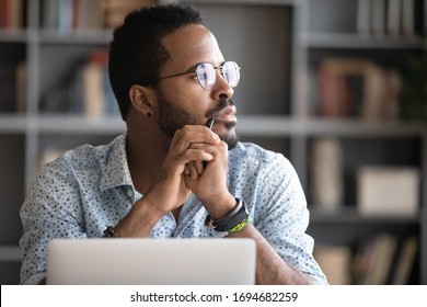 Pensive African American man in glasses distracted from computer work look in distance thinking or pondering, thoughtful biracial male lost in thoughts make plans visualizing, business vision concept - Powered by Shutterstock