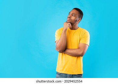 Pensive African American Man Thinking Touching Chin Looking Aside Posing Standing On Blue Background. Studio Shot Of Thoughtful Black Millennial Guy. Let Me Think Concept - Shutterstock ID 2029452554
