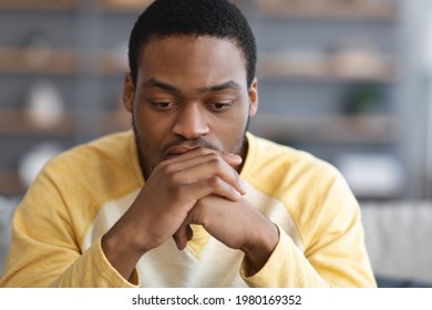 Pensive African American Young Man Thinking About Something, Closeup Portrait, Copy Space. Thoughtful Black Guy Having Heavy Thought, Leaning On His Hands And Looking Down, Experiencing Difficulties