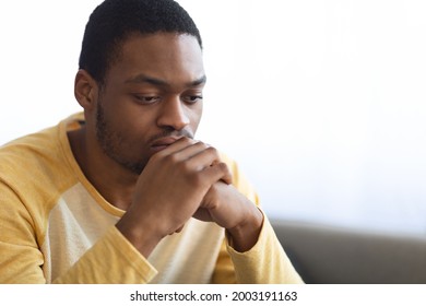 Pensive African American Young Man Thinking About Something, Closeup Portrait, Copy Space. Frustrated Black Guy Having Heavy Thoughts, Leaning On His Hands And Looking Down, Experiencing Difficulties