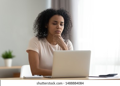 Pensive african American young woman sit at desk thinking studying or working on laptop at home, thoughtful black millennial girl student pondering considering idea looking at computer screen - Shutterstock ID 1488884084