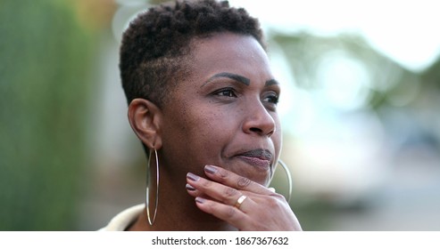
Pensive African woman thinking. Contemplative black lady in deep think outside