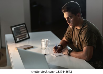 Pensive American Army Soldier Feeling Lonely While Writing Letter At Office Desk.