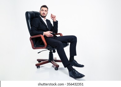 Pensive Angry Bearded Business Man In Formalwear Sitting In Black Office Chair And Holding Cellphone Over White Background