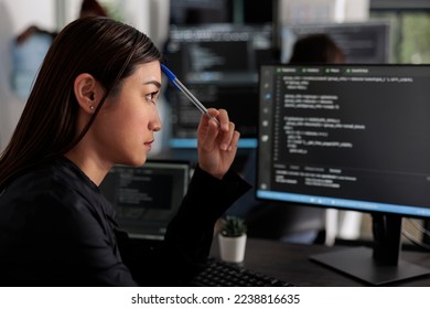 Pensive asian it programmer thinking at html script development, brainstorming ideas to create html code. It software developer working at database server in software office company