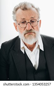 Pensive Bearded Grey Haired Stylish Elderly Business Man In Formal Black Suit, No Tie, Being Deep In Thoughts, Looks Aside, Isolated Over Dark