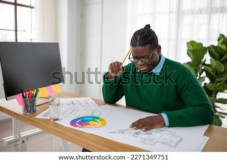 Pensive Black Engineer Man Making Technical Drawing Of An Object Thinking And Solving Problems Sitting At Desk In Modern Office. Architecture And Engineering Design Career Concept