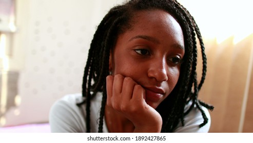 
Pensive Black teen girl child thinking. Thoughtful sad depressed teenager adolescent girl