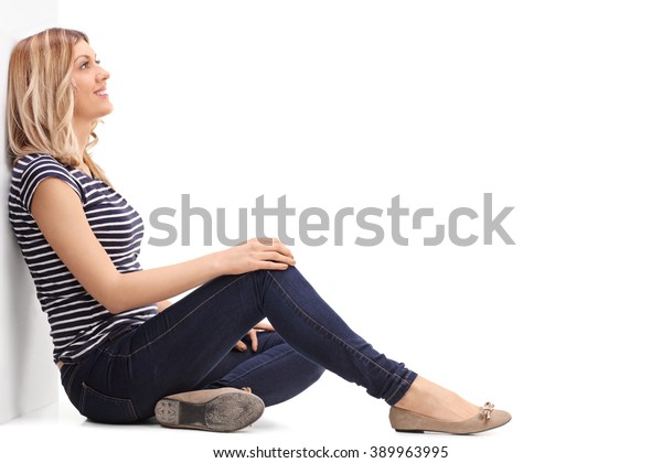 白い背景に壁に寄りかかる 床に座った哀れな金髪の女性 の写真素材 今すぐ編集