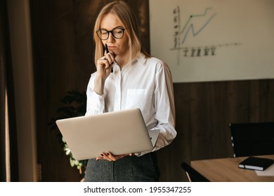 Pensive Business Woman Working At A Laptop, Thinking About A Heavy Task, Office Work. High Quality Photo