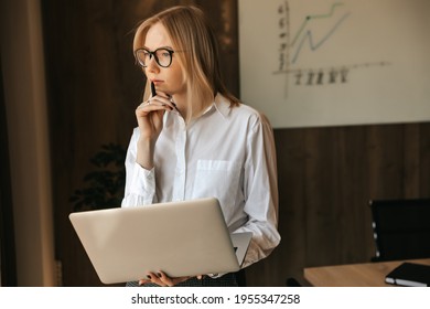 Pensive Business Woman Working At A Laptop, Thinking About A Heavy Task, Office Work. High Quality Photo