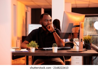 Pensive Businessman Brainstorming Ideas To Work On Research Data, Reading Email On Computer. Thoughtful Freelancer Being Focused About Charts Report And Paperwork In Office With Big Windows.