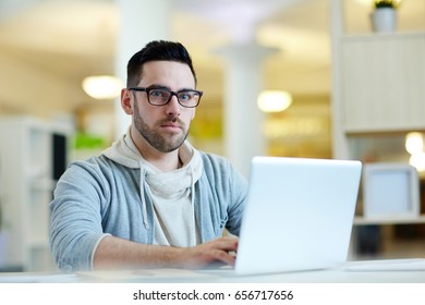 Pensive businessman sitting by workplace and typing - Shutterstock ID 656717656