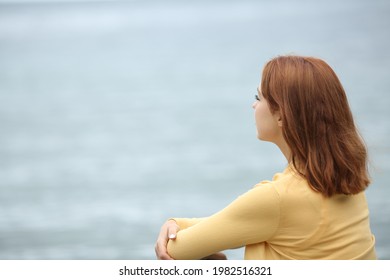 Pensive Casual Woman Contemplating Ocean On The Beach