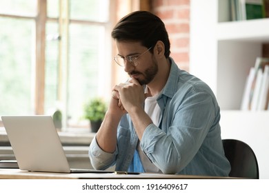 Pensive Caucasian Male Employee Look At Laptop Screen Work On Gadget Thinking Pondering. Thoughtful Man Worker Use Computer Consult Client Online, Analyze Report Or Solve Business Problem In Office.