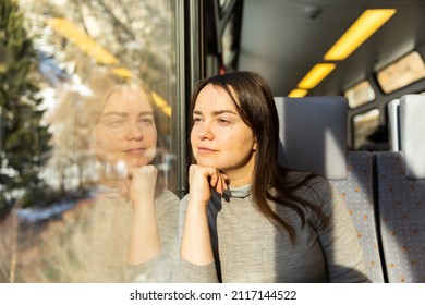 Pensive Caucasian Woman Traveler Sitting Inside Train And Looking Out Window.