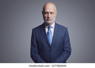 Pensive corporate businessman posing on gray background, business and finance concept - Shutterstock ID 2177820443