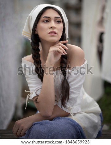 Pensive country woman in white headscarf