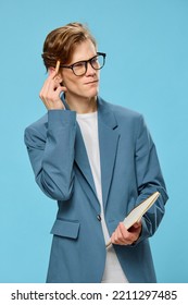 Pensive Cute Guy In A Jacket And Glasses On A Blue Background