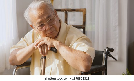 Pensive disabled elderly patient sit on wheelchair alone, Sad and depressed lonely Asian senior old man head down feel lonely and bored waiting for take care white room dementia and Alzheimer - Powered by Shutterstock