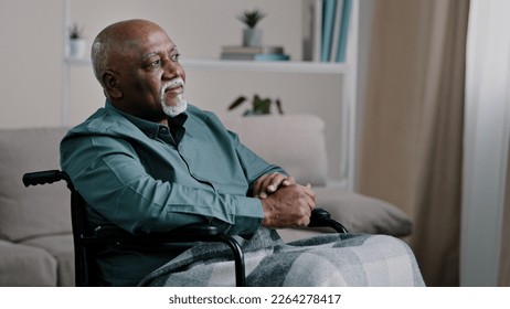 Pensive dreaming calm alone elderly patient. old African bald man with gray beard senior mature grandpa sit on wheelchair at home looking away dreams thinking ponders deep in memories Alzheimer - Powered by Shutterstock