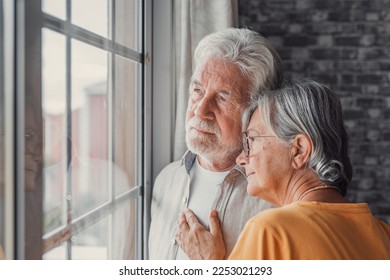 Pensive elderly mature senior man in eyeglasses looking in distance out of window, thinking of personal problems. Old woman wife consoling and hugging sad husband, copy space - Shutterstock ID 2253021293