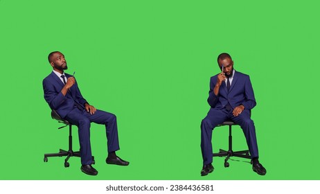 Pensive employee thinking about solutions sitting on chair, posing over green screen wearing business office suit. Male entrepreneur brainstorming new ideas and feeling confident. - Powered by Shutterstock