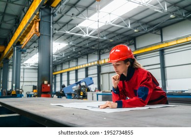 Pensive Engineer Looking At Blueprint At Work In Heavy Industry Hall.