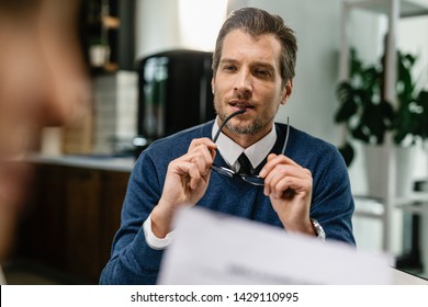 Pensive Financial Advisor Listening To Client During The Meeting. 